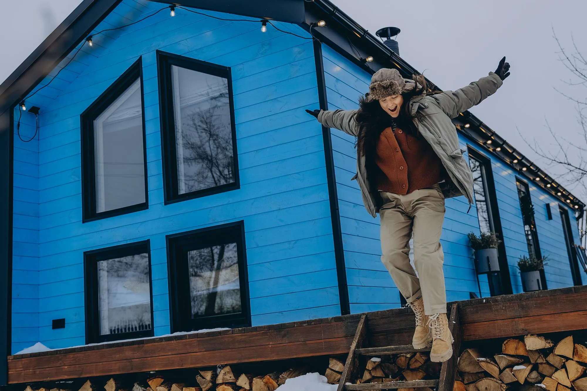 020124 Bar Ukraine young woman dressed in warm country clothes on the background of a country house for vacation enjoying the winter view of the village