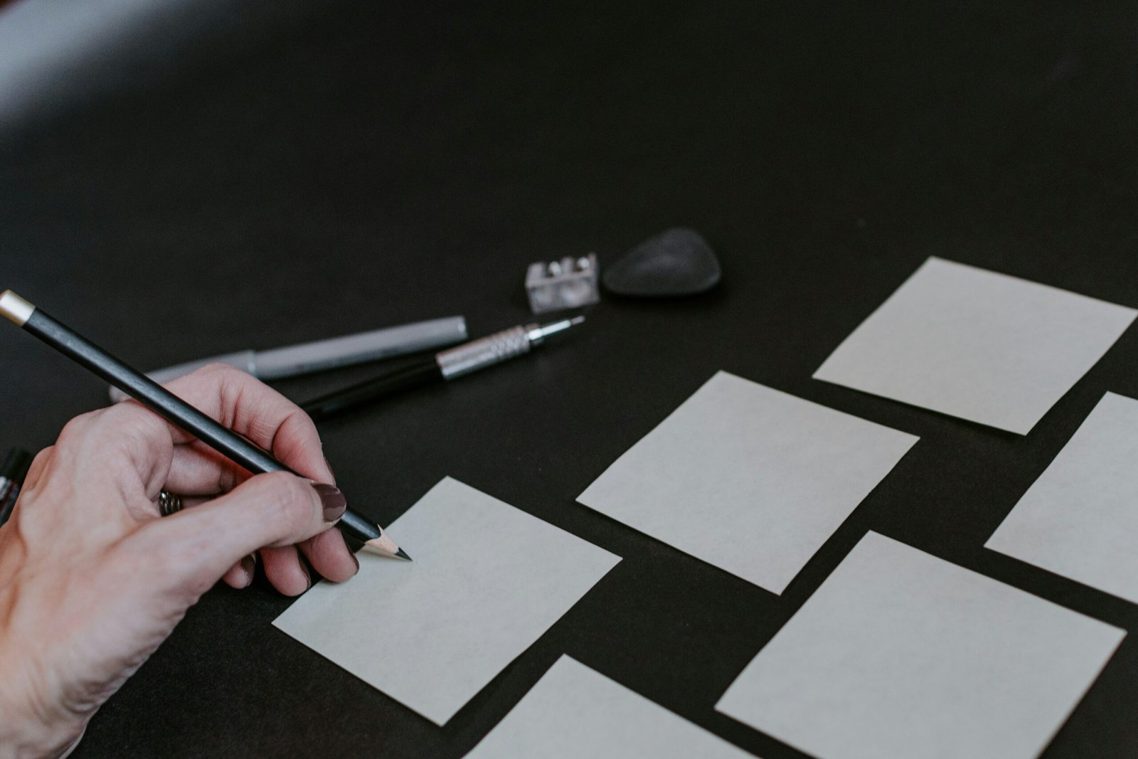 A person is drawing squares on a table