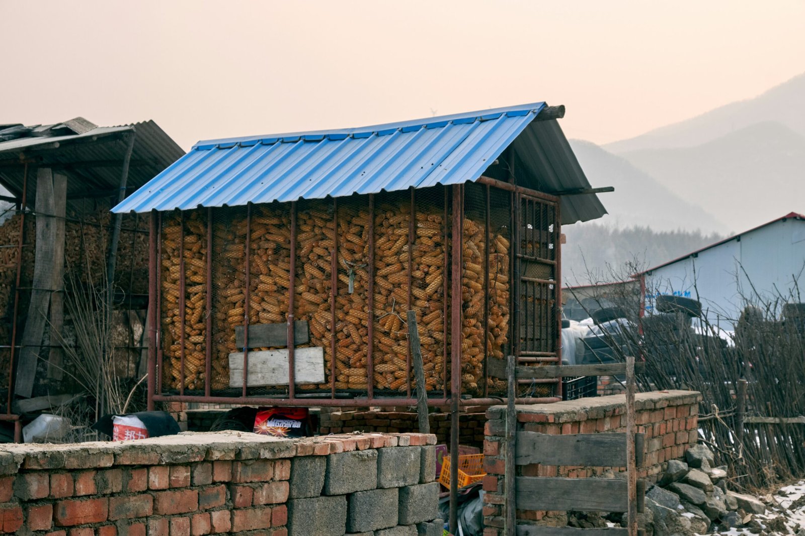 a building with a blue roof and a pile of wood