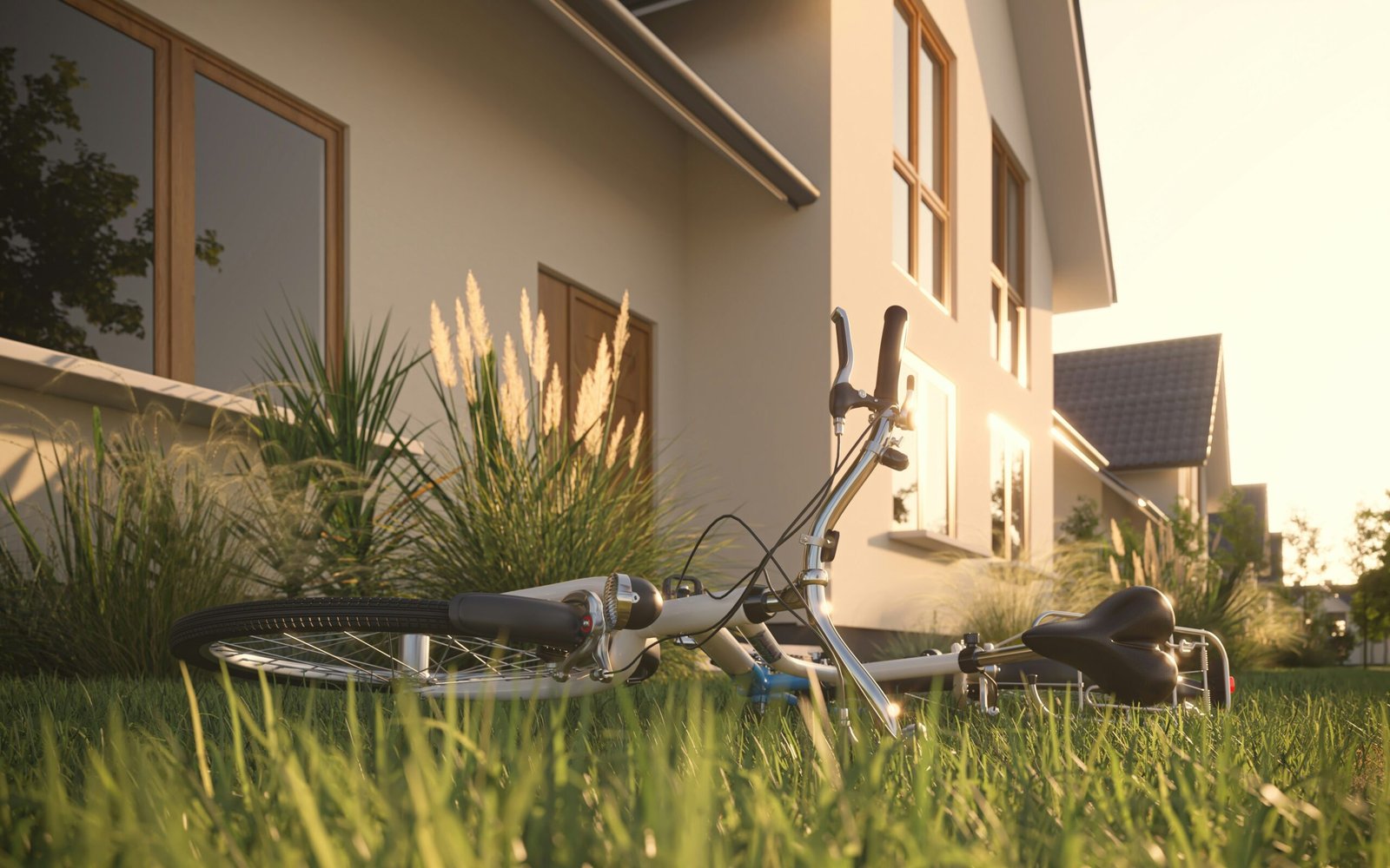 a bicycle laying in the grass in front of a house