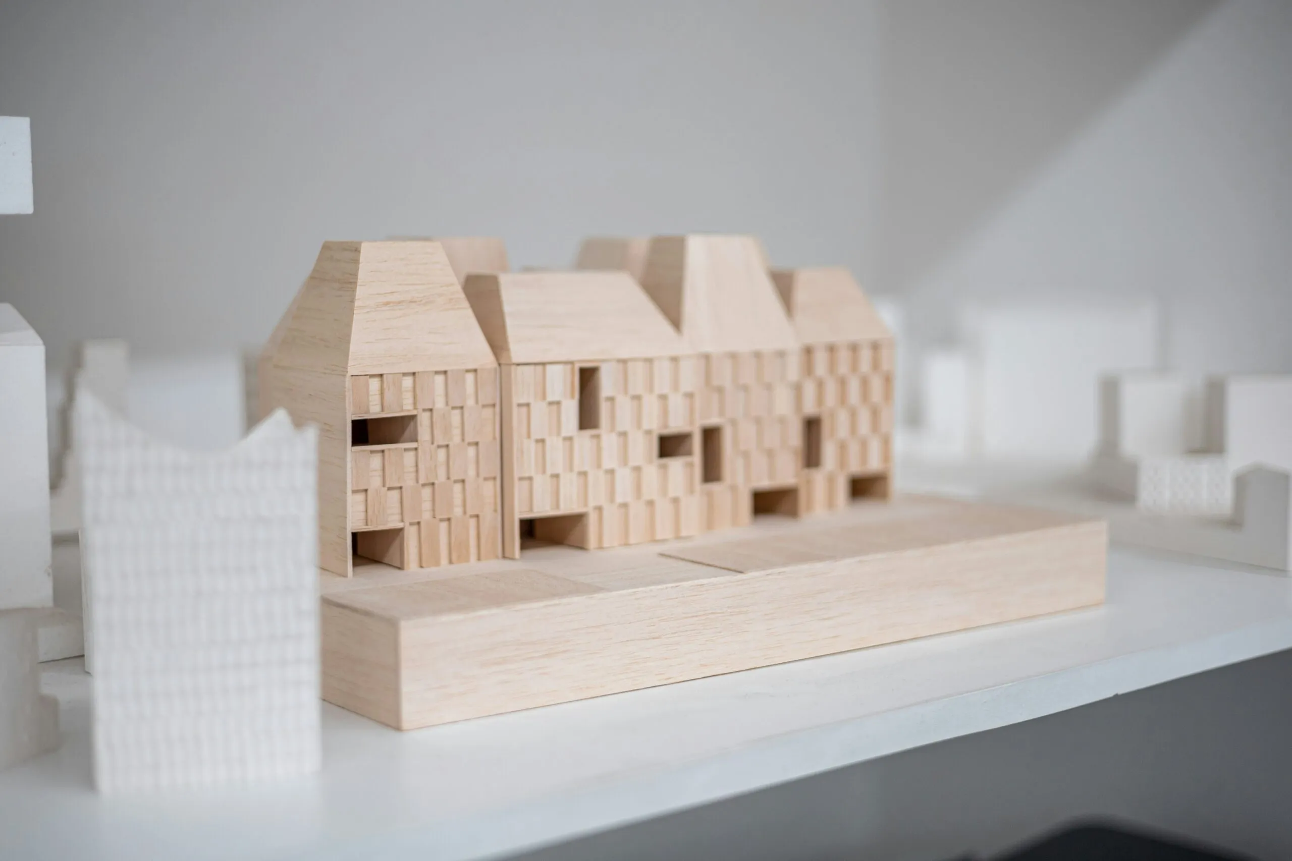 A wooden model of a house on a table