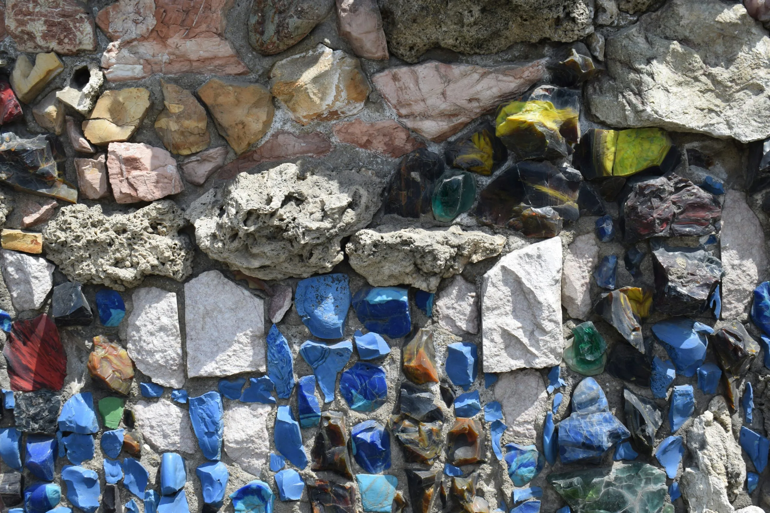 a stone wall covered in lots of different colored rocks