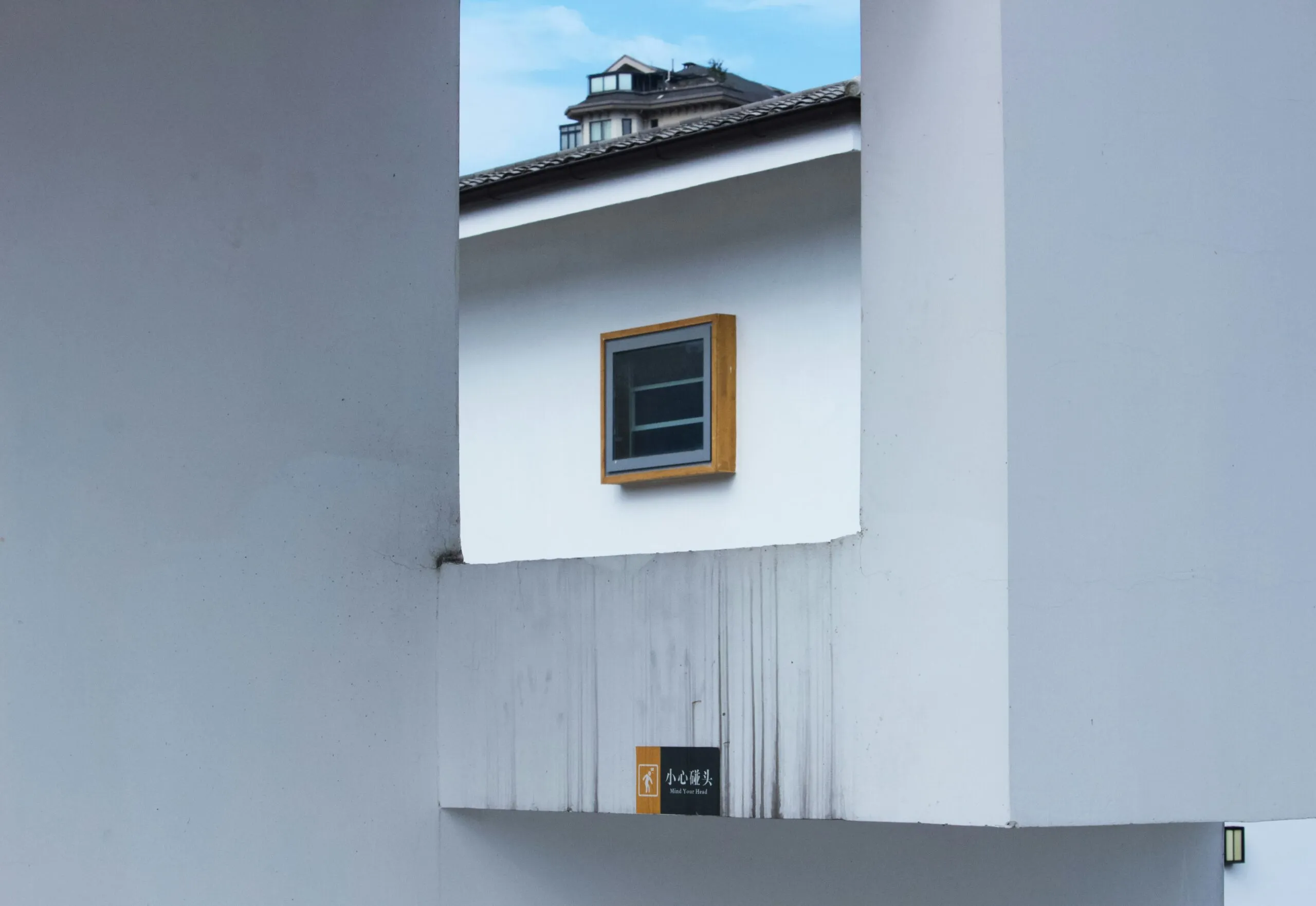 white concrete building with yellow window