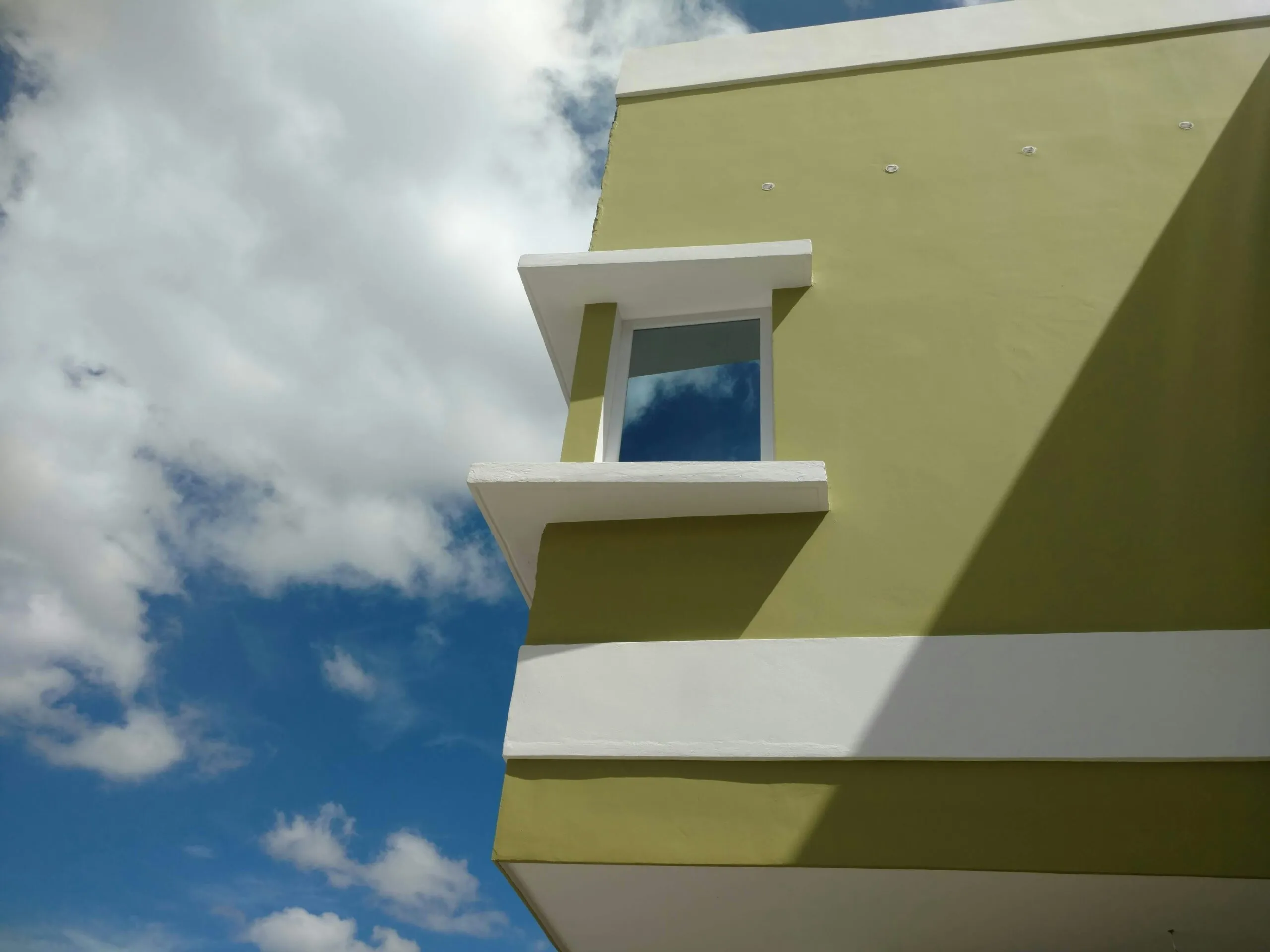 a yellow and white building with a blue sky in the background