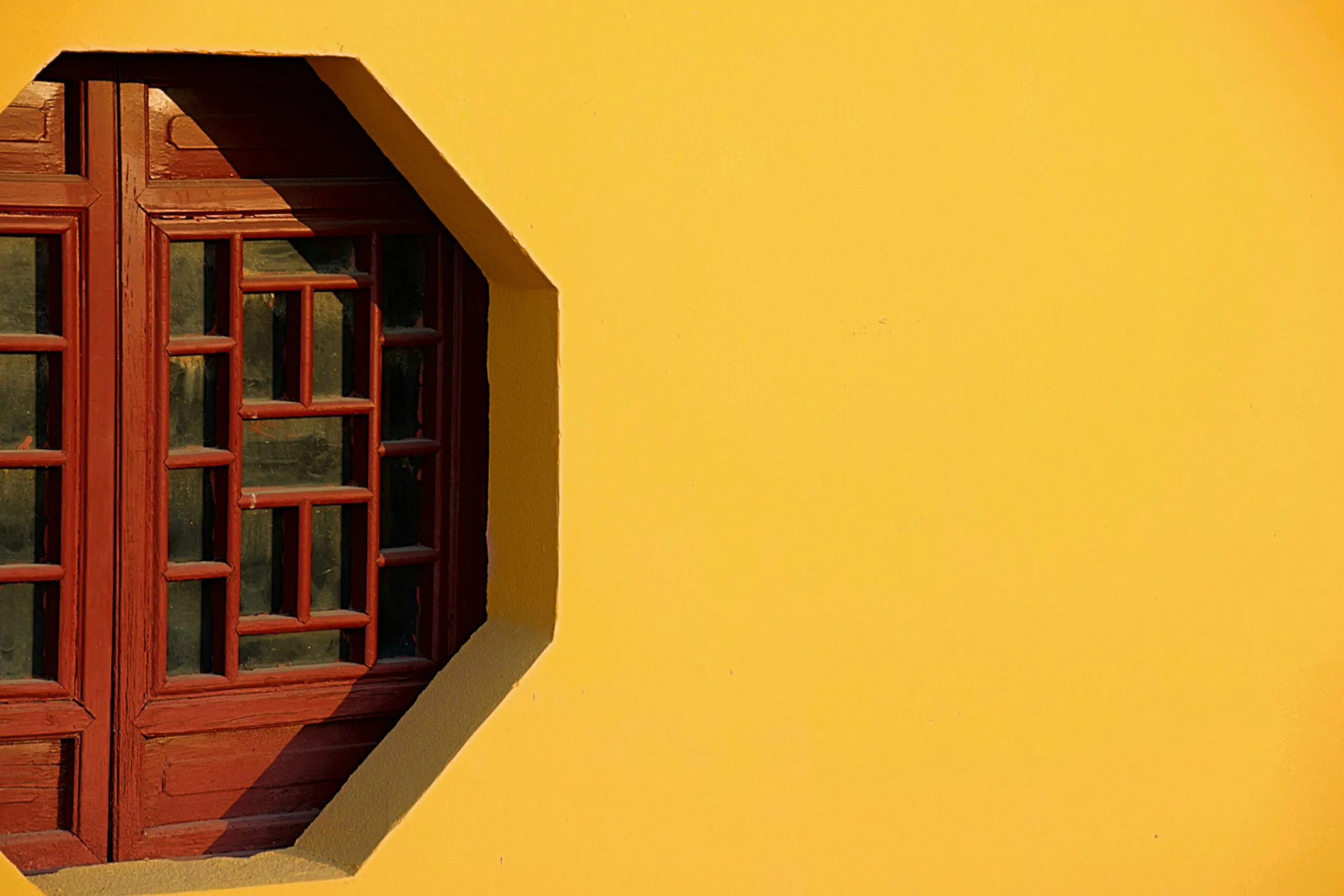 A wooden window in an octagonal opening.