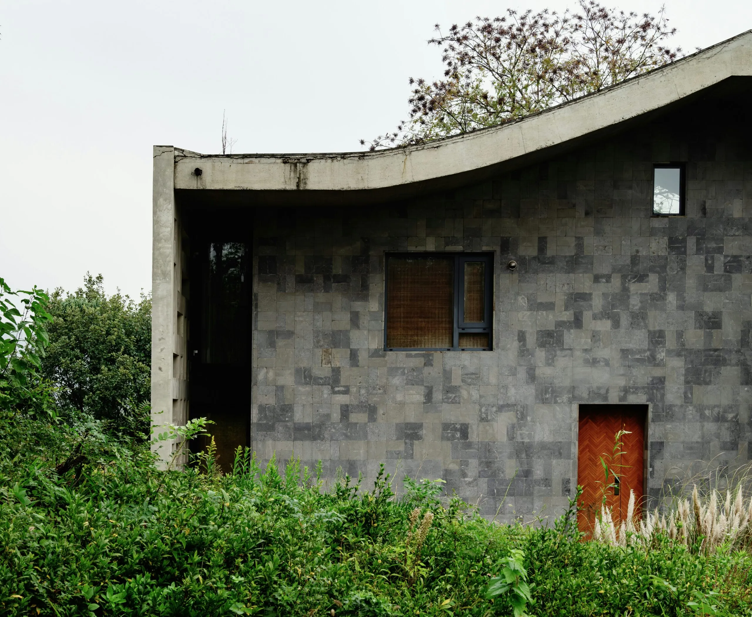 A house with a curved roof and a red door