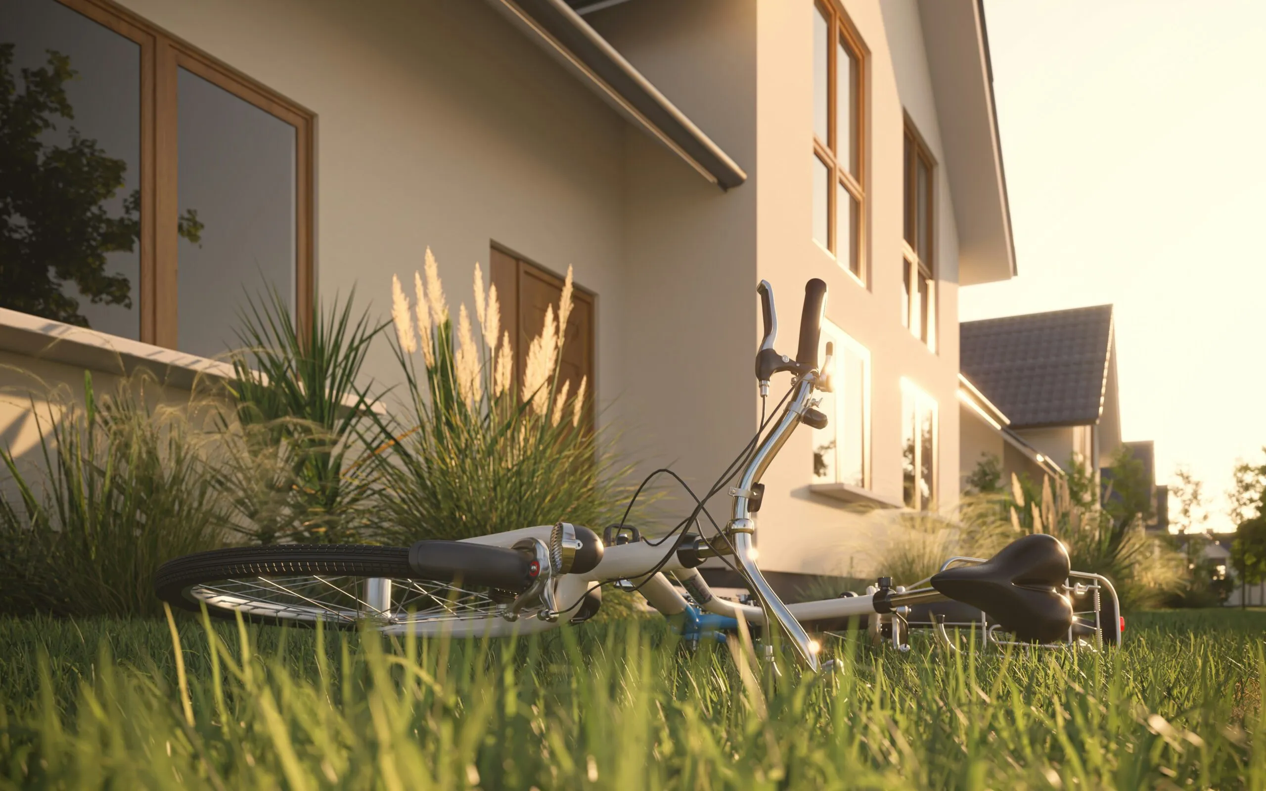 a bicycle laying in the grass in front of a house
