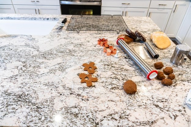 Baking christmas gingerbread cookies in modern white kitchen
