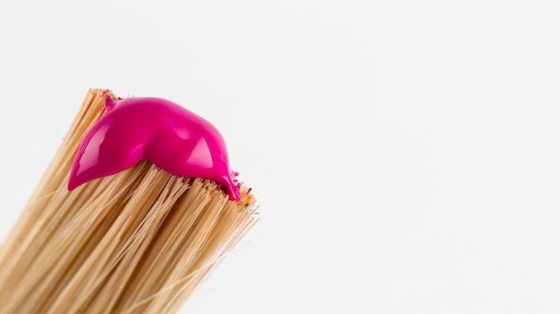 Brush with pink paint and copy space