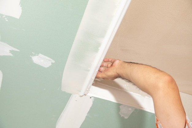 Caucasian worker renovating ceiling at home