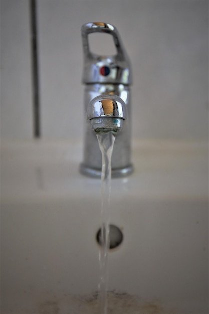 Close-up of water falling from faucet in bathroom