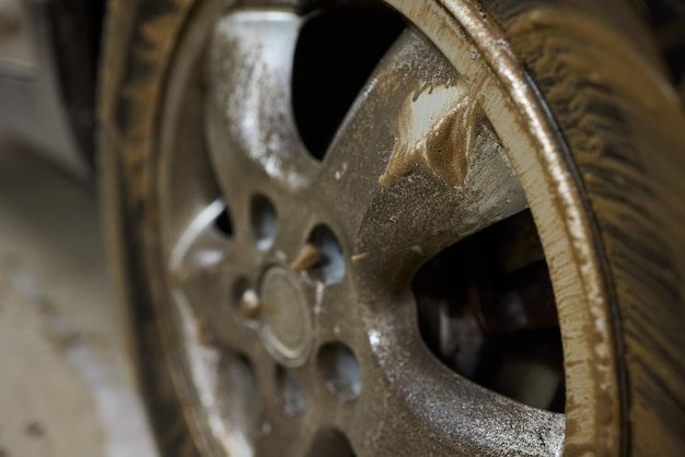 Closeup shot depicting a Dirty Car Wheel that is covered with Mud and Grime buildup