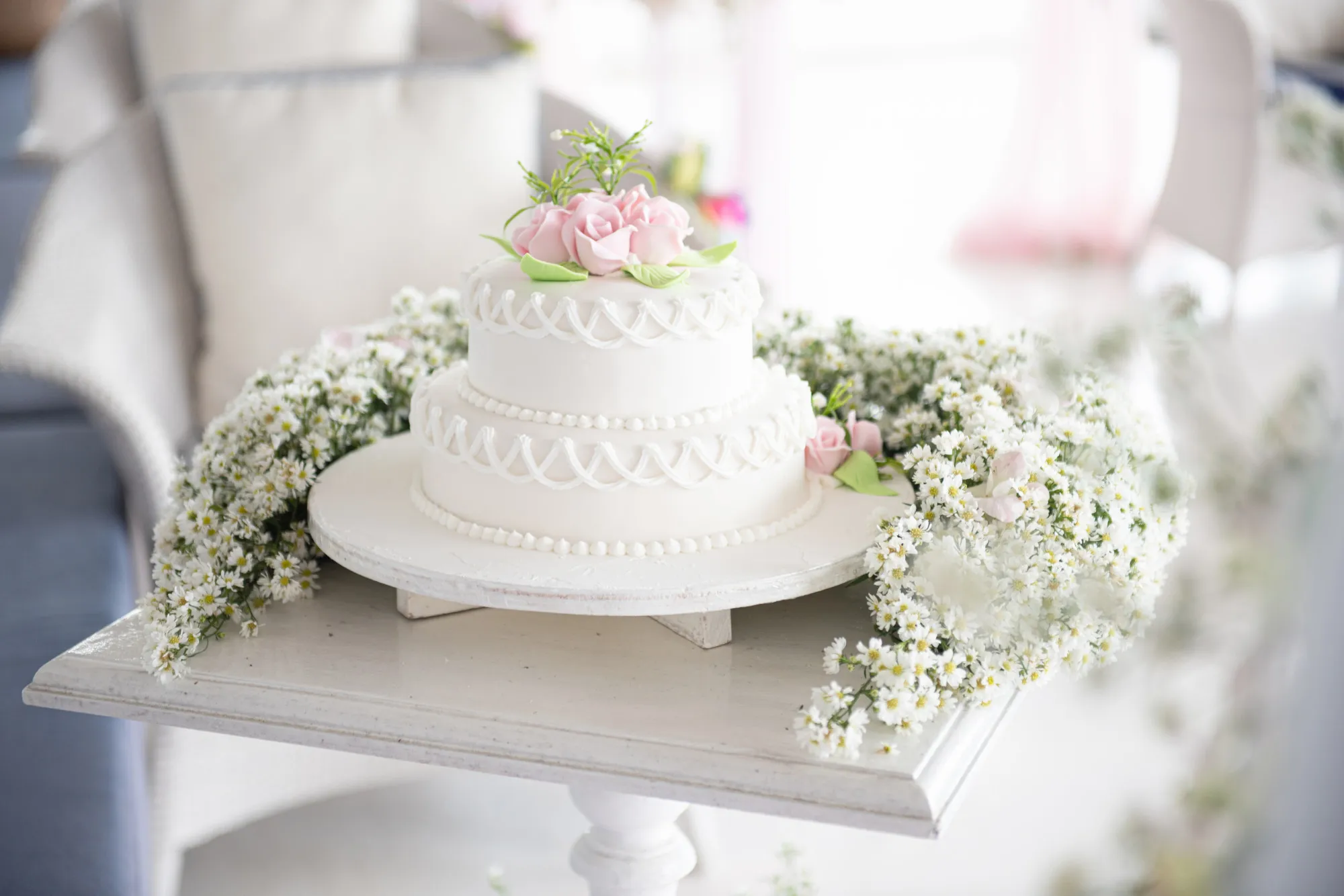 Elegant white wedding cake with flowers and succulents at wedding avenue reception.