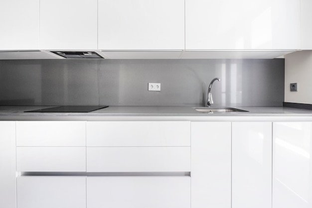 Front image of a modern kitchen furnished in white and gray tones in a vacation rental unit