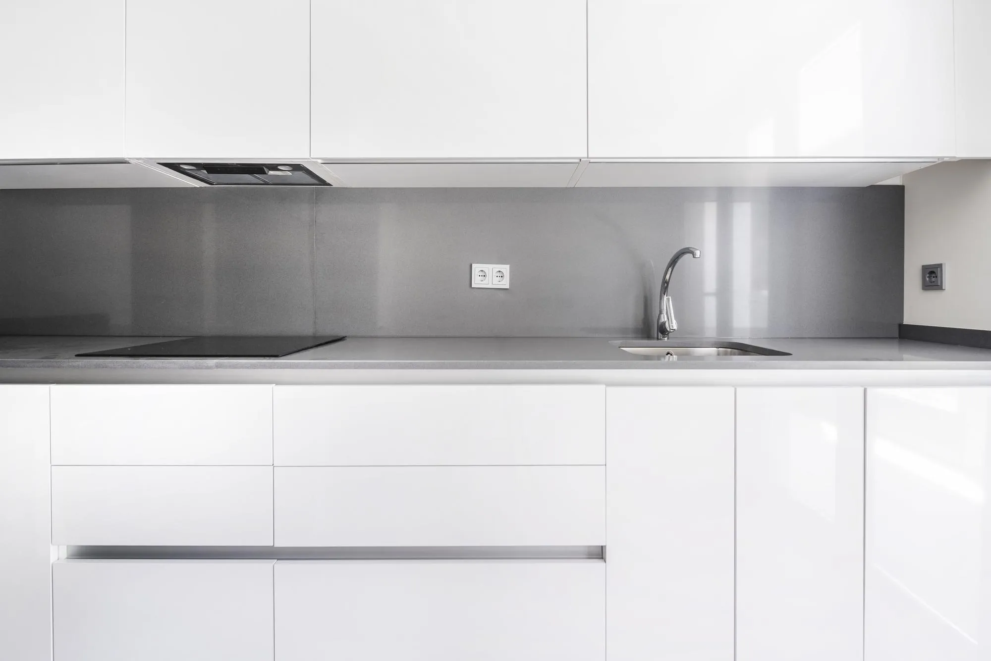 Front image of a modern kitchen furnished in white and gray tones in a vacation rental unit