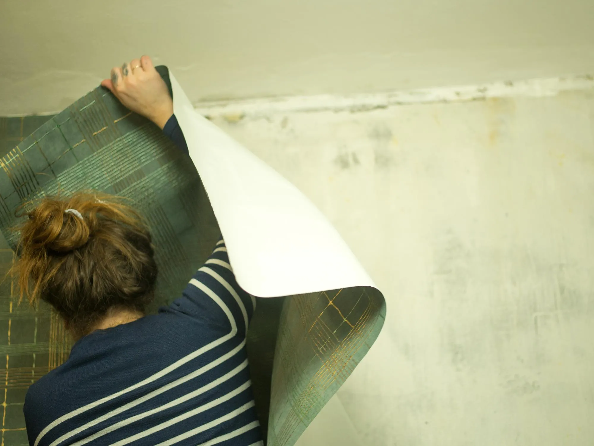 girl pasting wallpaper in the hallway apartment renovation