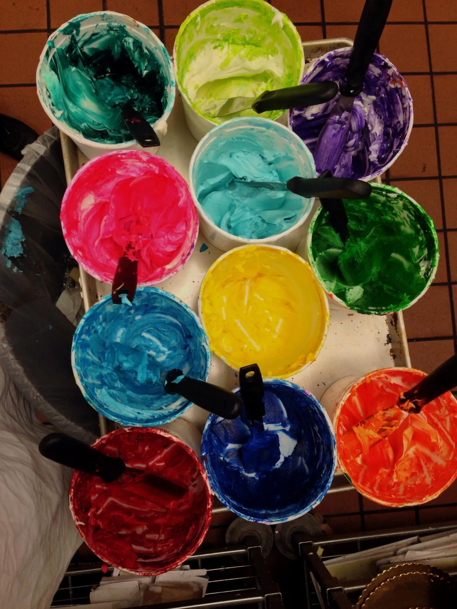 High angle view of multi colored cake icing in cups
