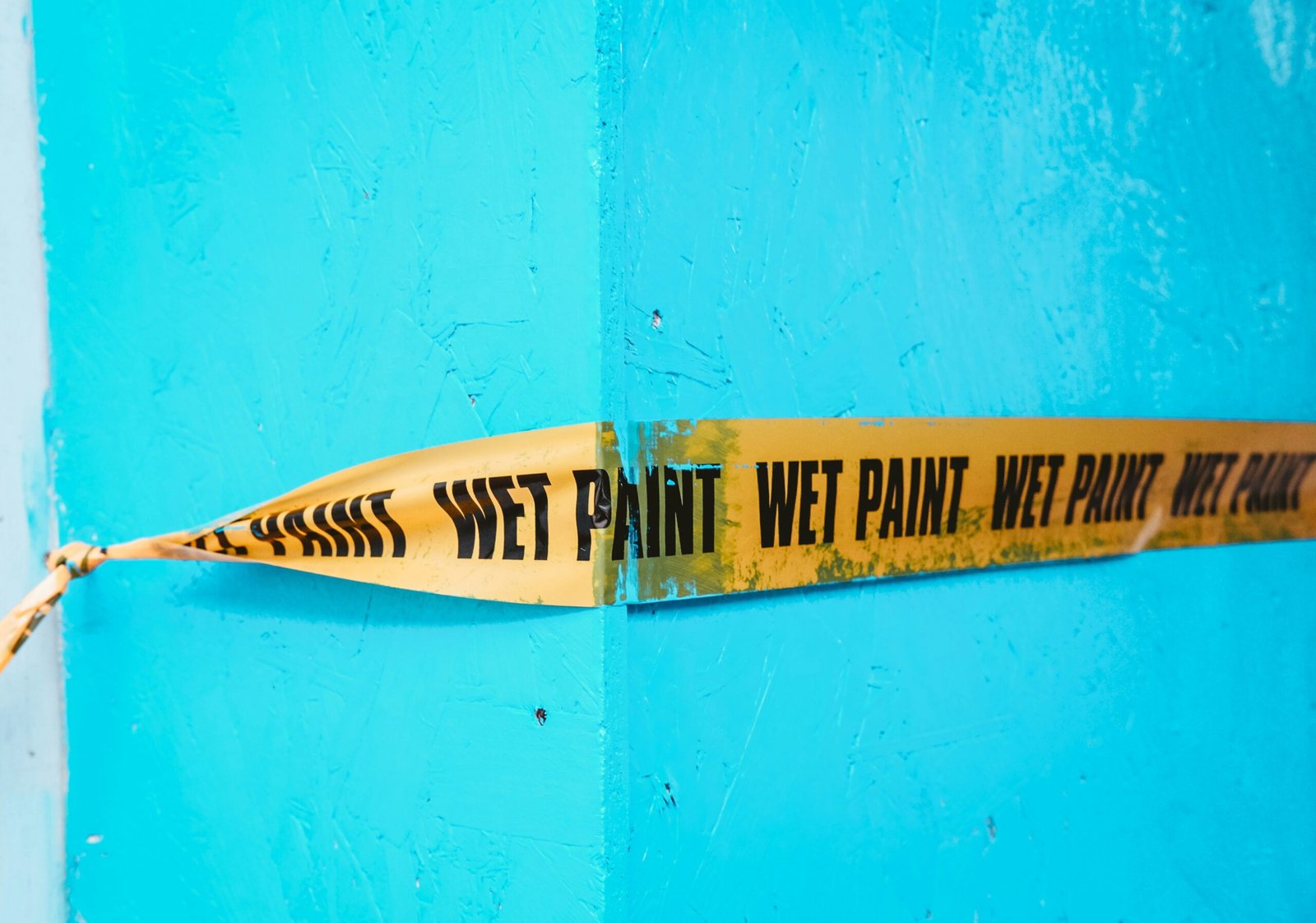 a yellow and black sign on a blue wall