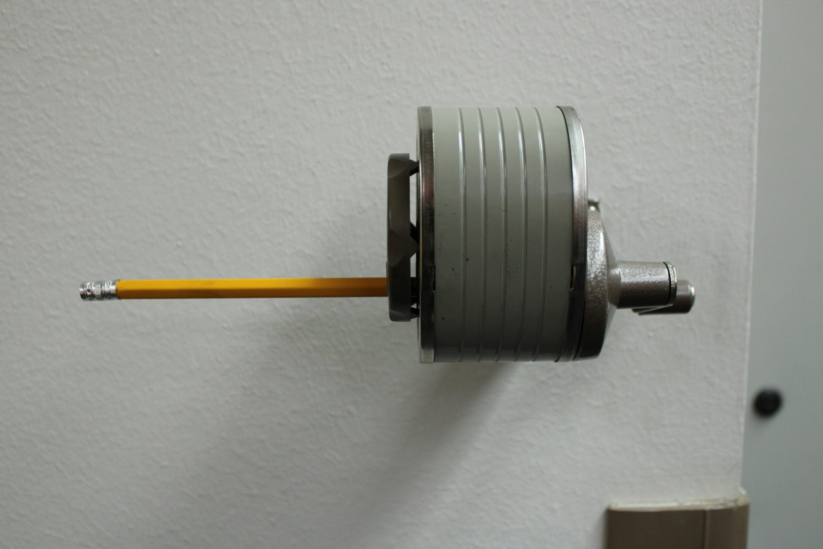 A pencil is held in a mechanical device.