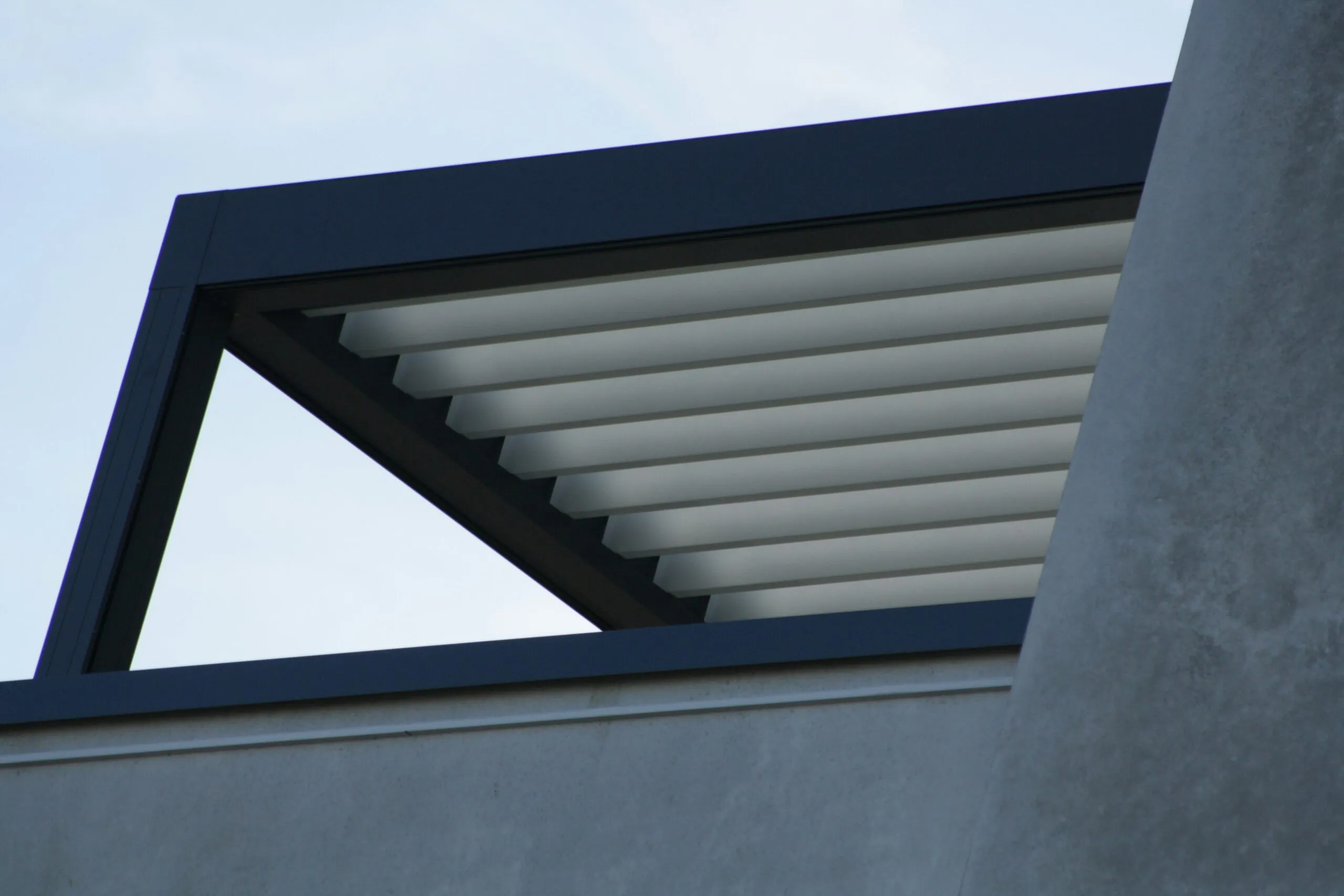 Modern pergola with adjustable louvers against sky
