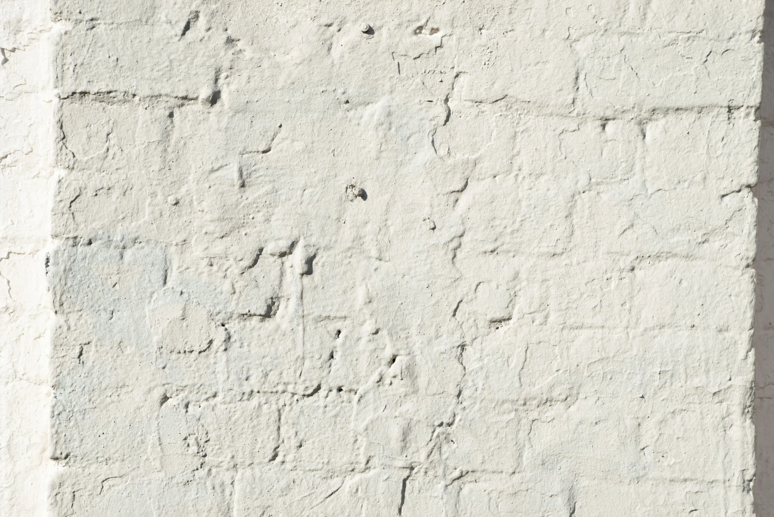 a white brick wall with a small crack in it