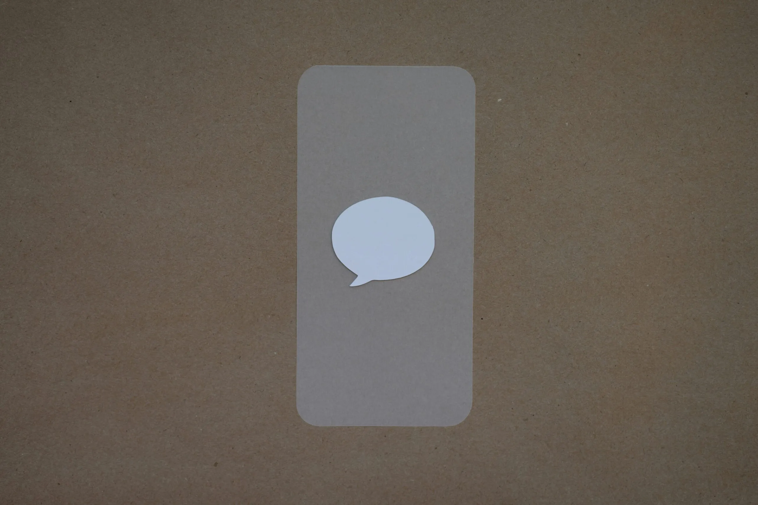 a white speech bubble sticker on a brown background