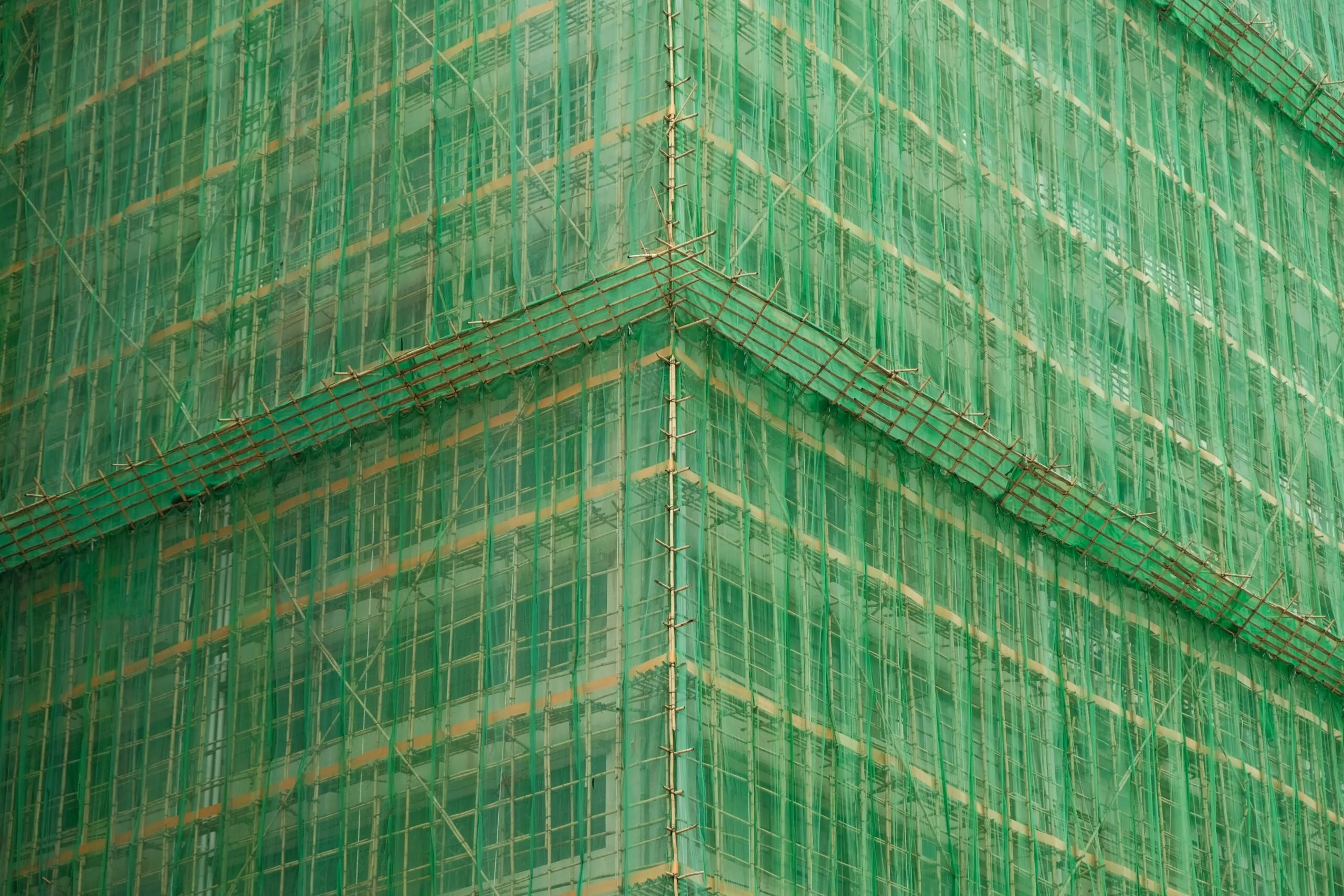 A tall green building with lots of windows