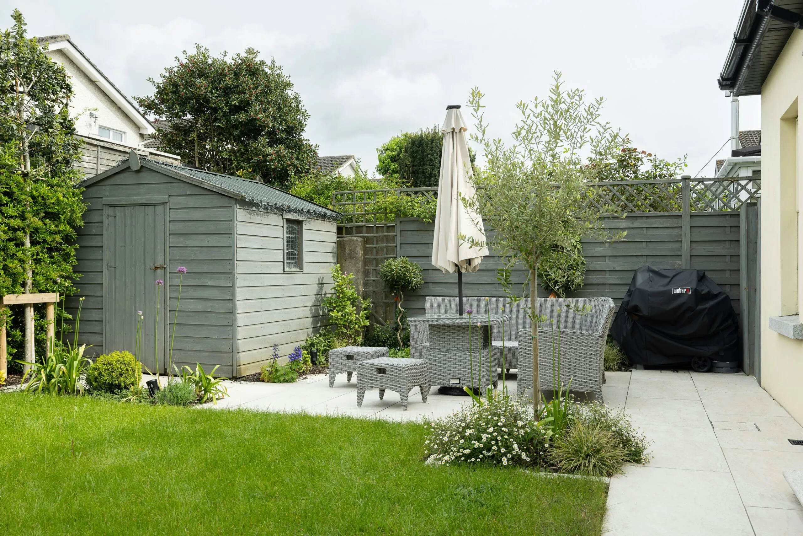 A backyard with a table and chairs and an umbrella