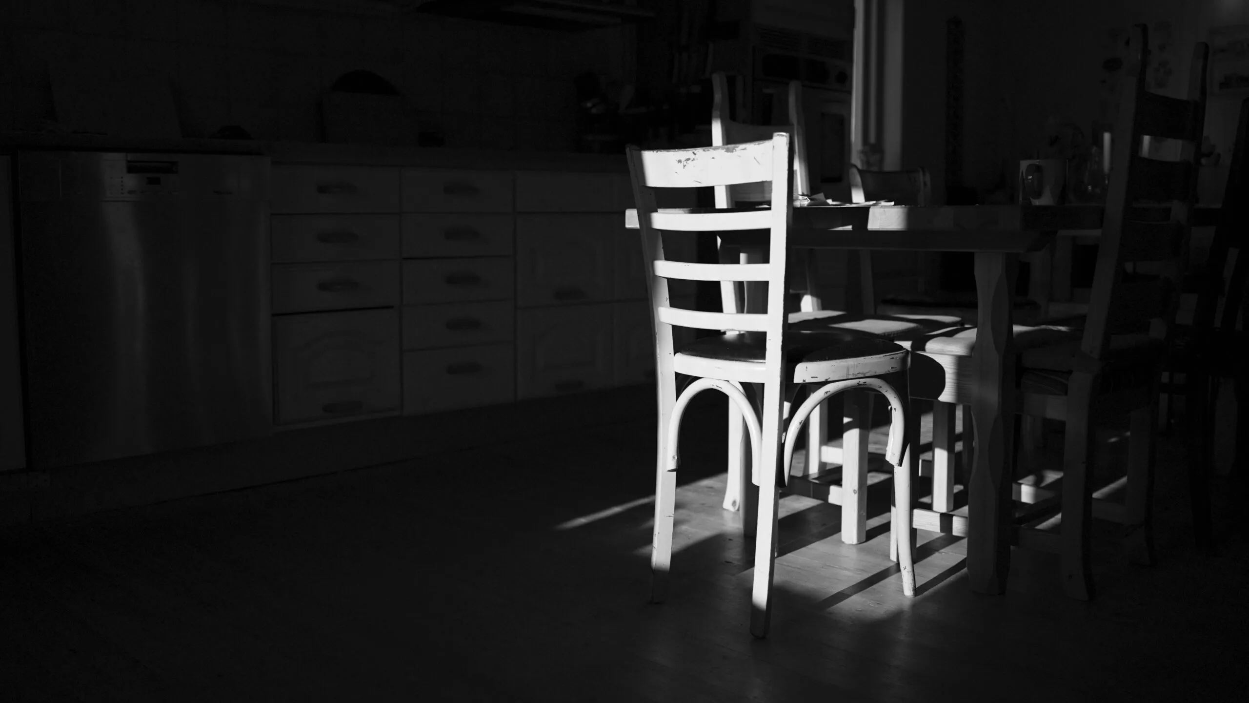 A black and white photo of a chair and table