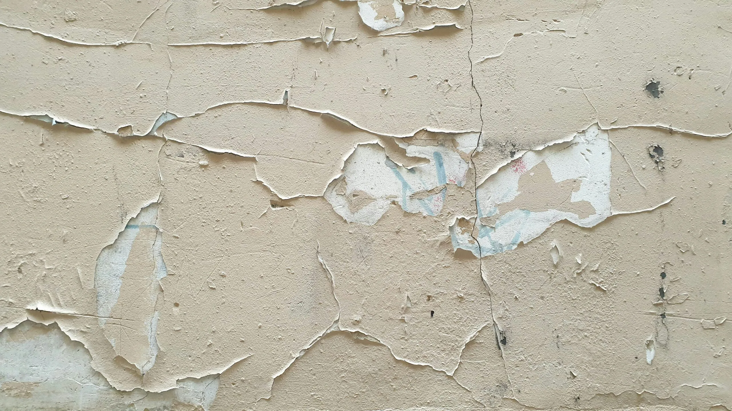 A close up of a wall with peeling paint