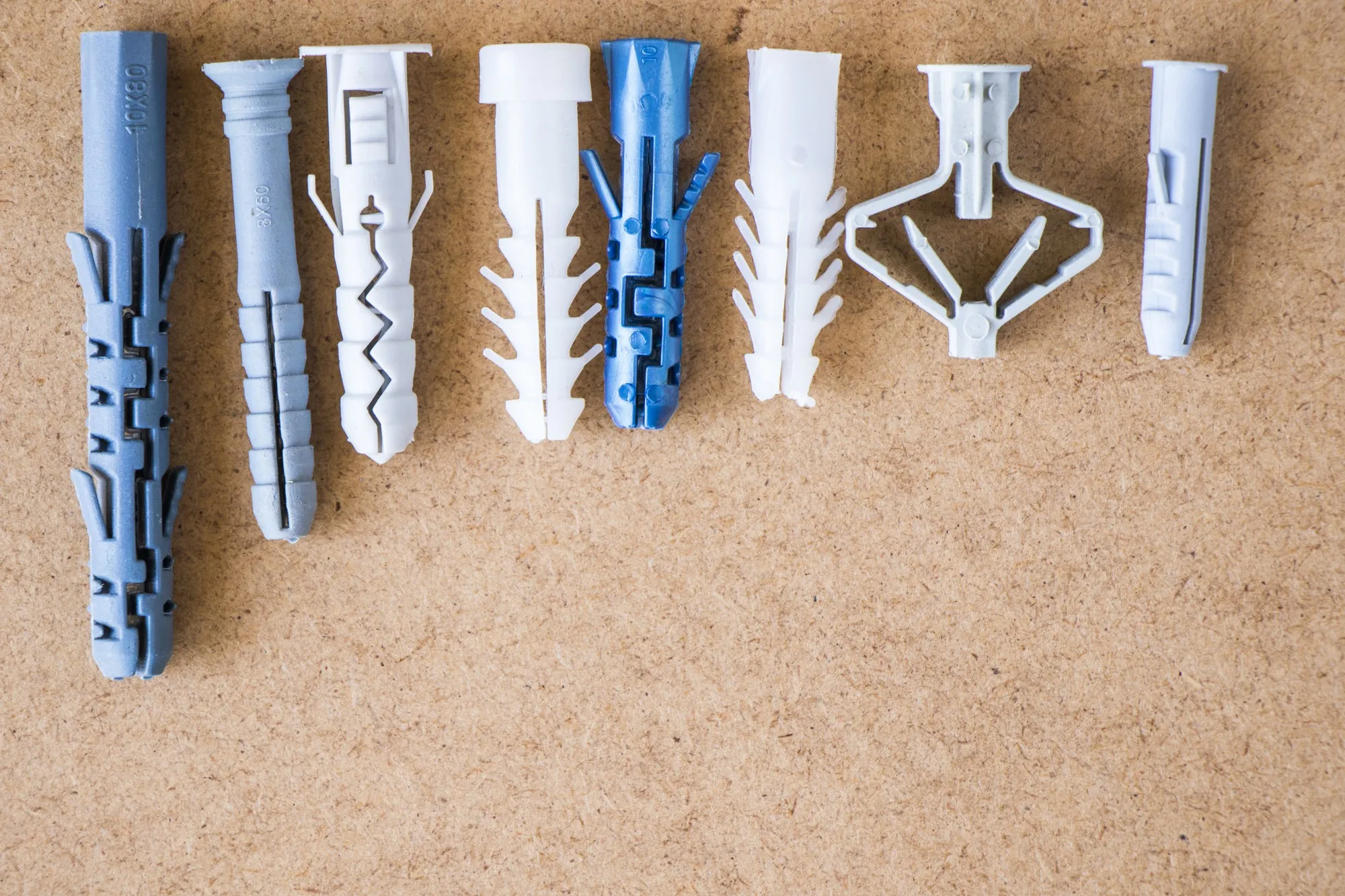 Large group of different plastic wall plugs on the brown background, high angle view