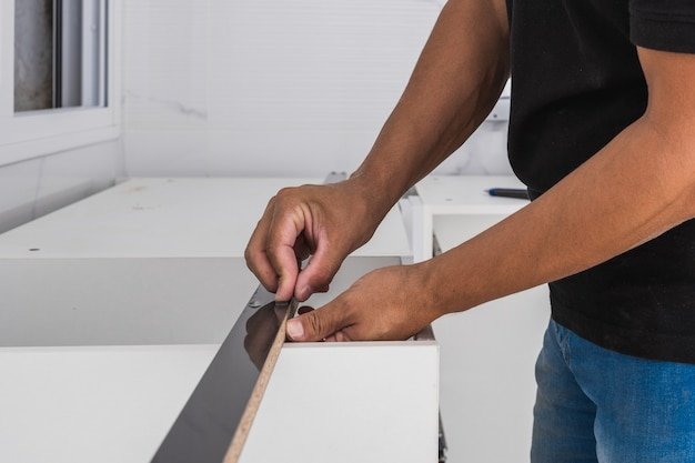Man fitting pieces of furniture he is assembling