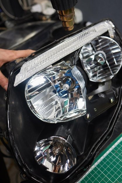Person fixing Automotive lighting with screwdriver on Motor vehicle headlight