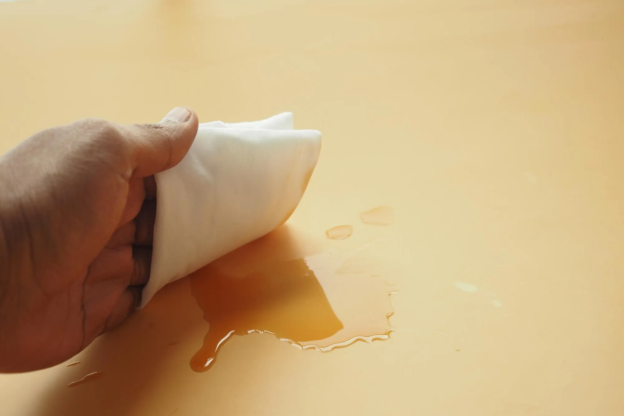 Person hand cleaning table with cloth