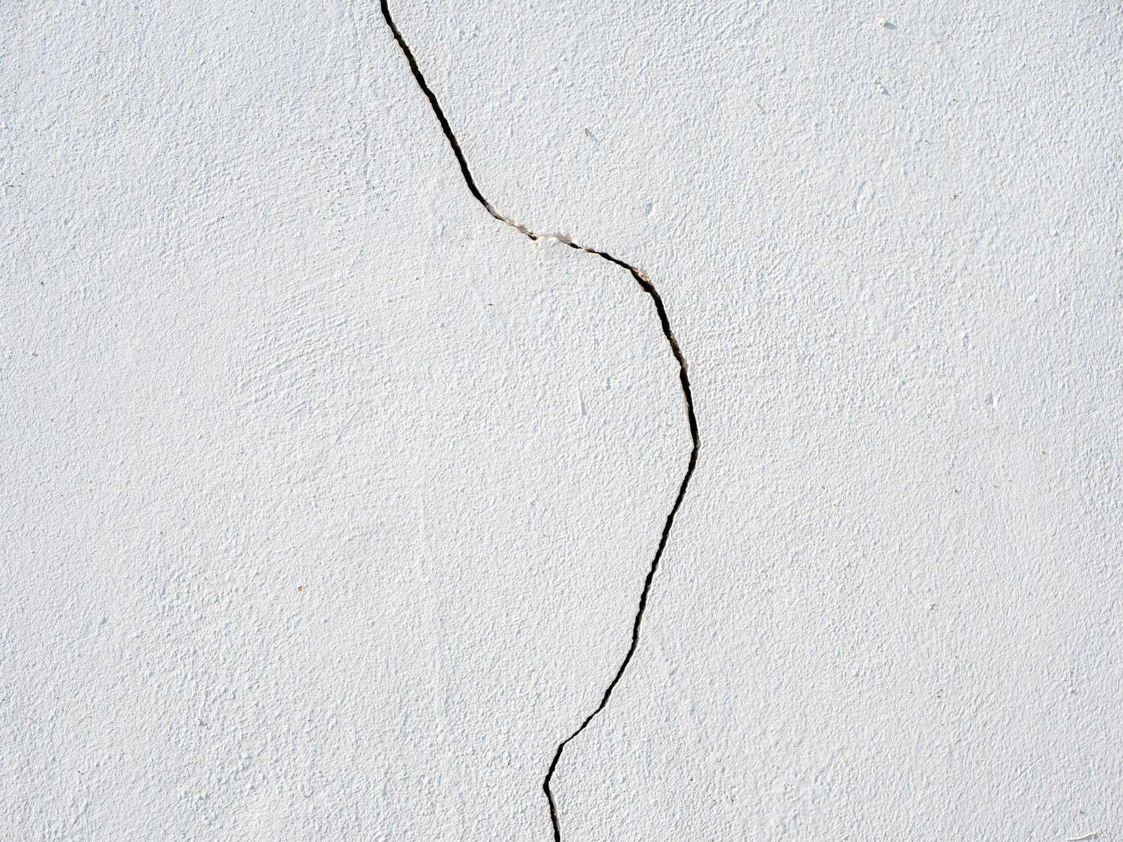 Photo of a vertical crack on a white wall