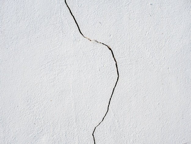 Photo of a vertical crack on a white wall