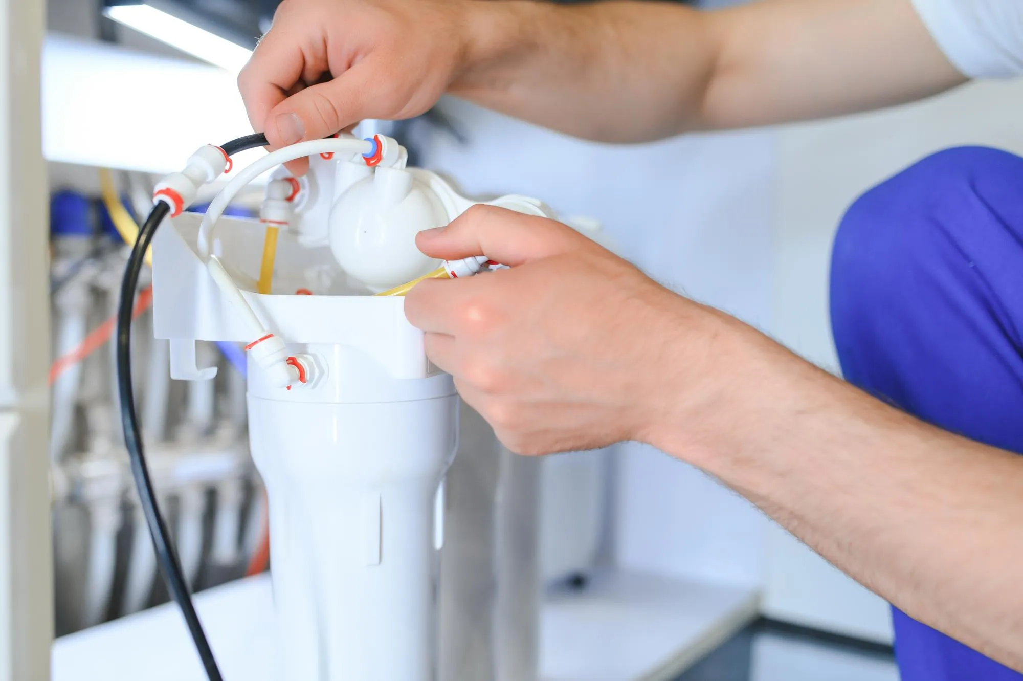 Plumber installs or change water filter Replacement aqua filter Repairman installing water filter cartridges in a kitchen Installation of reverse osmosis water purification system