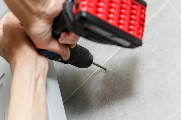 Rapairman drilling ceramic tile on a wall