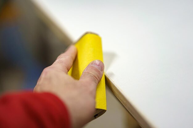 Sanding down burrs on a piece of furniture in a carpentry shop Furniture manufacturing plant