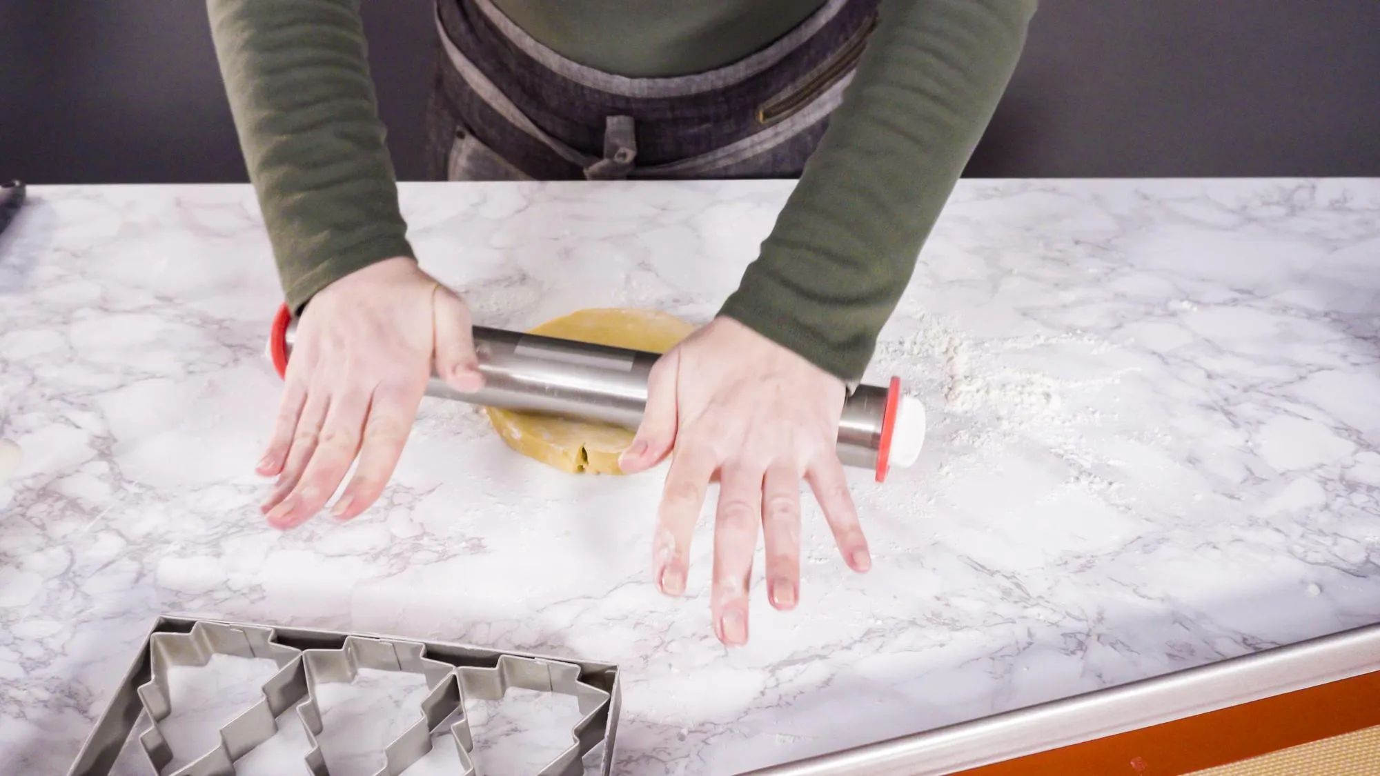 Step by step. Rolling out sugar cookie dough to bake Christmas cookies.