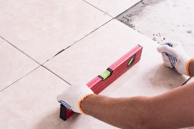 Tiler installing ceramic tiles on a floor