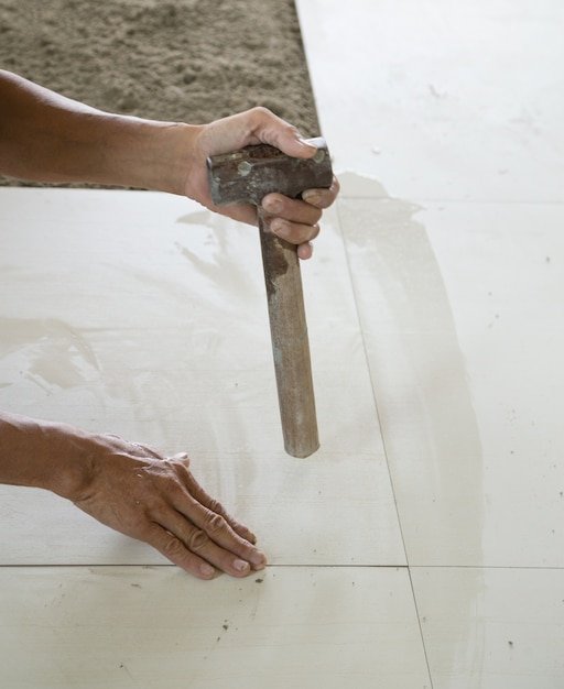 Worker working tiled at construction site.