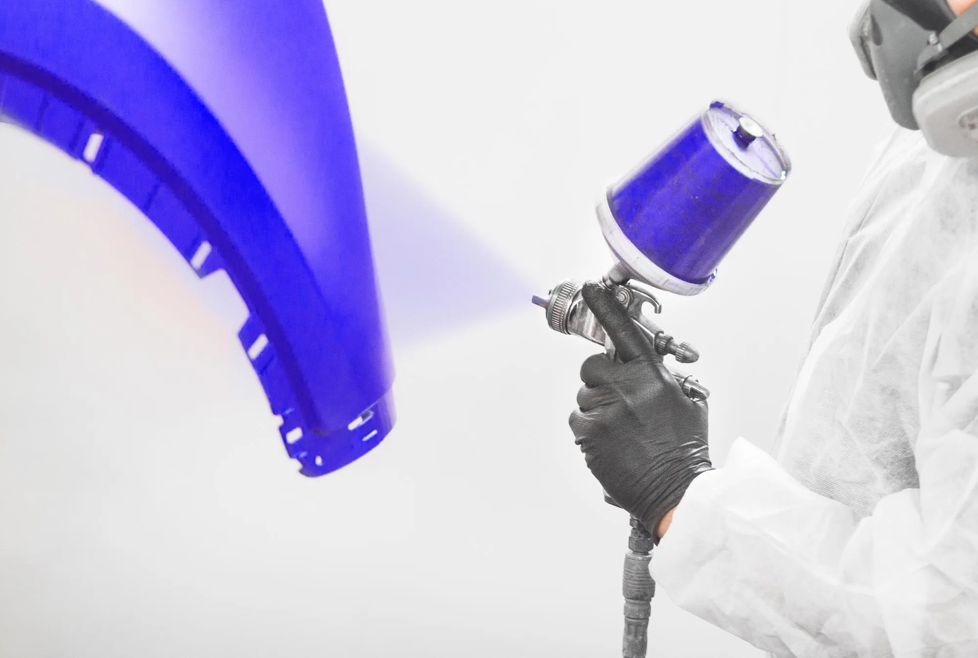 Application of first layer spray painting of the car bumper Repair restoration of vehicle after the accident