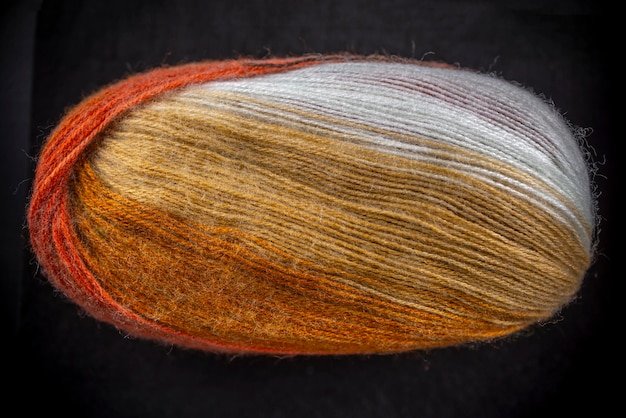 A ball of yarn with a gold and white stripe