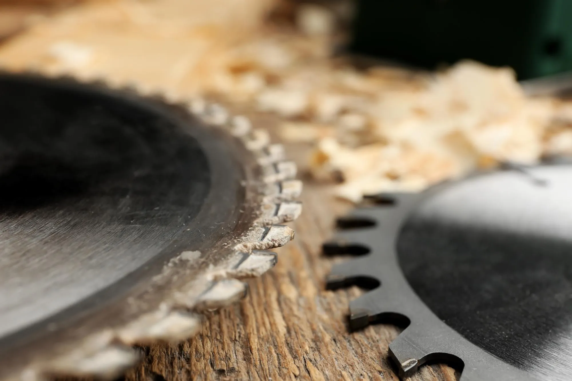 Circularsaw disks on wooden table in carpenters workshop closeup