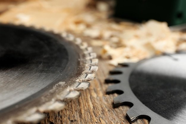 Circularsaw disks on wooden table in carpenters workshop closeup