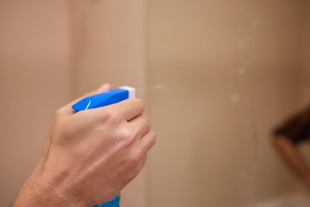 Cleaning and polish mirror with rag and spray in bathroom at home Housekeeping and cleaning service Clean house cleanliness