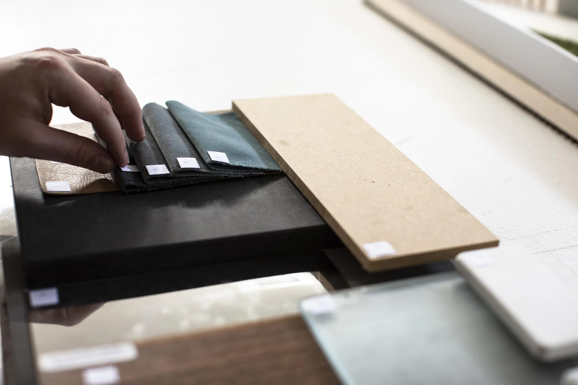 Close-up of person working on table with material samples