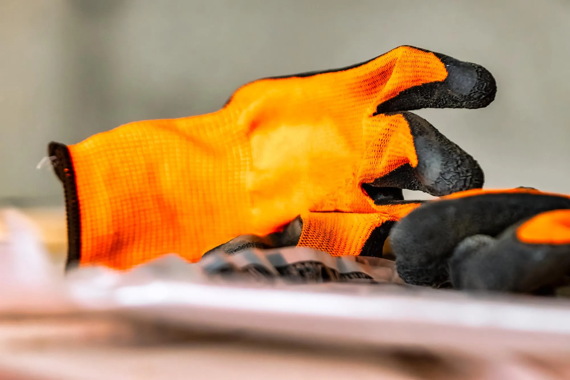 Construction rubberized gloves at a construction site Orange protective rubber gloves for construction and operation with caustic substances or for repair Garden gloves for work in the garden