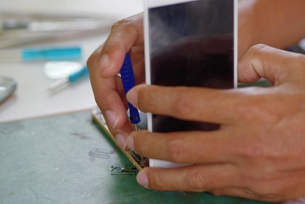 Cropped hands repairing mobile phone